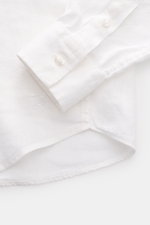 Close-up, top-down view of the cuff and hem of the Vilebrequin Linen shirt slim collar white, showing lightweight fabric, soft feel, regular fit, narrow collar, French button placket, classic barrel cuffs, patch breast pocket, rounded hem, and tonal stitc