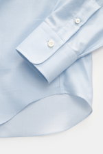 Close-up view of the sleeve and hem of the Gherardi Casual shirt shark collar light blue, twill made of cotton and cashmere, soft flannel, slim fit, French button placket, classic sport cuff, split back yoke, rear waist darts, rounded hemline.