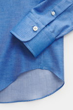 Close-up image of the cuff and rounded hemline of the Gherardi Casual shirt shark collar blue melange, photographed from above, highlighting twill made of cotton and cashmere, soft flannel, slim fit, shark collar, french button placket, classic sport cuff
