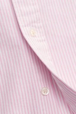 Nahaufnahme von Knopf und Streifenmuster des Polo Ralph Lauren Oxford-Hemd Button-Down-Kragen rosé/weiß gestreift aus reiner Baumwolle.