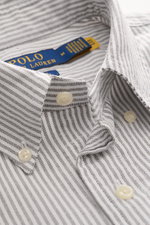 Close-up angled view of the Polo Ralph Lauren Oxford Shirt Button-Down Collar Black/White Striped, showing striped pure cotton fabric, button-down collar with detailed buttons, and visible brand label inside collar. Stylish classic with attention to detai