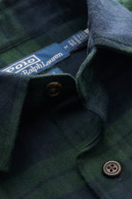 Nahaufnahme aus schräger Perspektive des Polo Ralph Lauren Flanellhemd schmaler Kragen navy/dunkelgrün kariert mit weichem Baumwoll-Flanell, Karo-Design, Knöpfen und Label.

Beschreibung (Inhalt aus Text integriert): Angenehm weicher Karo-Klassiker mit Li