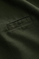 Nahaufnahme des dunkelgrünen 04651/ A trip in a bag Casual Hemd 'Winter Cotton' mit Kent-Kragen, Baumwoll-Gabardine, weichem Griff und Leistentasche, perspektivisch von schräg oben fotografiert.
