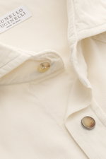 Close-up front view of the Brunello Cucinelli Cord Shirt Shark Collar Cream, showcasing fine cotton corduroy, soft touch, slim fit, shark collar, patch breast pockets with curved flap, patch snap button placket, classic sport cuff, western-style shoulder 