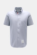 Front view of Thom Browne short sleeve shirt button-down collar smoky blue in pure cotton Oxford fabric with patch pocket and button placket.