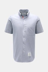 Front view of Thom Browne short sleeve shirt button-down collar smoky blue in pure cotton Oxford fabric with patch pocket and button placket.