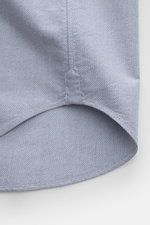 Close-up of the slightly rounded hem of the Thom Browne Short sleeve shirt button-down collar smoky blue, showing pure cotton Oxford fabric with detailed stitching from a bottom-up perspective.