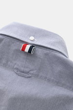 Thom Browne Short sleeve shirt button-down collar smoky blue shown from the back yoke close-up, featuring pure cotton Oxford fabric, soft feel, regular fit, button-down collar, patch button placket, patch breast pocket, back yoke with inverted pleat and h
