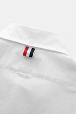Close-up rear view of Thom Browne Short-sleeve shirt button-down collar white, showcasing back yoke with inverted pleat, hanging loop, and button.
