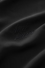 Detailaufnahme des schwarzen Ami Paris Kurzarmhemds 'Boxy' Kubanischer Kragen mit Logo-Stitching auf weicher Viskose, gerundetem Saum.