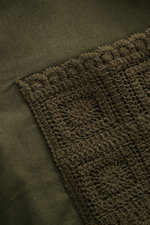 Nahaufnahme des Häkel-Details am Saum des Ché Kurzarmhemds 'Inigo' Offener Kragen dark olive aus Leinen-Baumwoll-Mix.