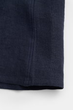 Close-up of the lower hem of the Percival Short sleeve shirt Cuban collar navy, showing navy pure linen fabric and detailed stitching from a front perspective. Relaxed summer style: With its lightweight linen fabric, this short sleeve shirt by PERCIVAL is