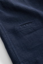 Nahaufnahme des dunkelblauen 04651/ A trip in a bag Leinen-Kurzarmhemd Kubanischer Kragen navy mit feiner Leinenstruktur, kleiner Münztasche und Saumdetail, fotografiert aus schräger Perspektive.