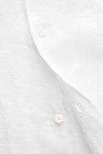Close-up front view of the 04651/ A trip in a bag Linen short sleeve shirt Cuban collar white showing pure linen fabric, French button placket, airy texture, and lightweight feel. Effortless lightness: this short sleeve shirt in pure linen by 04651/ A TRI