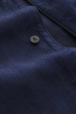 Nahaufnahme aus seitlicher Perspektive des Jacquemus Denim Kurzarmhemd dunkelblau aus reiner Baumwolle mit Regular Fit, offenem Kragen, aufgesetzter Brusttasche und dekorativer J-Schlaufe.
