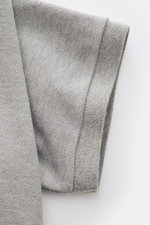 Nahaufnahme des leicht griffigen Ärmels vom Thom Browne Poloshirt grau meliert aus reiner Baumwolle in Slim Fit mit Rippbündchen.