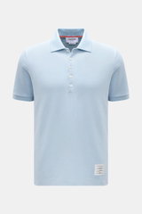 Vorderansicht des Thom Browne Poloshirts hellblau aus reiner Baumwolle, Slim Fit mit klassischem Polokragen, Fünf-Knopf-Leiste, Rippbündchen an Ärmeln und elastischen Seiteneinsätzen, markentypisches Streifen-Logo.