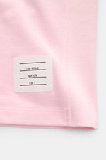 Nahaufnahme des Thom Browne Poloshirt rosé am unteren Saum mit markentypischem Streifen-Logo aus reiner Baumwolle, Slim Fit.