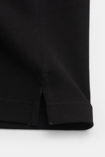 Close-up of the side hem slit of the Stone Island Poloshirt schwarz, showing the black cotton piqué fabric and textured knit from a side perspective, highlighting the slim fit and garment-dyed material. 

Description: <p>Das klassische Poloshirt ist ein M