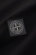 Close-up view of the Stone Island Poloshirt schwarz showing the textured black cotton piqué fabric and the stitched Stone Island logo patch.

Description: <p>Das klassische Poloshirt ist ein Must-have in der sportiven Herrengarderobe: Aus Baumwoll-Piqué g