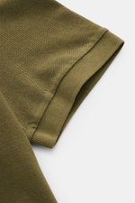 Nahaufnahme des kurzen Ärmels vom Stone Island Poloshirt oliv aus Baumwoll-Piqué, slim fit mit flexiblem Ärmelbündchen, seitlichem Saumschlitz.