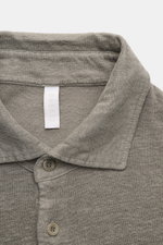 Close-up front view of the collar and buttons of the 04651/ A trip in a bag Linen jersey polo shirt grey-green, made from stretchy, breathable linen. This casual, piece-dyed jersey polo shirt from 04651/ A TRIP IN A BAG is made from stretchy linen, which 