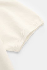 Nahaufnahme des Ärmels vom Fioroni Kurzarm-Strickpolo creme aus Leinen-Baumwoll-Mix, luftiges, feines Strickbild, flexible Rippbündchen.