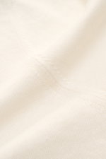 Fioroni Kurzarm-Strickpolo creme aus Leinen-Baumwoll-Mix, feines Strickbild, weicher Griff, Detailaufnahme aus Nahperspektive.