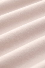 Nahaufnahme des beigen Fedeli Jersey-Poloshirts 'Zero' aus Bio-Baumwolle, mit glattem Griff und feiner Jersey-Struktur, detailreich fotografiert.