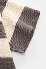 Ami Paris Kurzarm-Strickpolo grau/creme gestreift, aus reiner Baumwolle, Regular Fit, mit Polokragen, Drei-Knopf-Leiste, Herz-Stitching, in Nahaufnahme von der Ärmelperspektive.