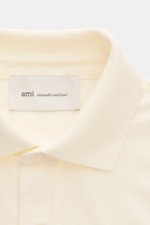 Close-up front view of Ami Paris Polo shirt cream showing signature collar, three-button placket, and textured piqué cotton fabric with logo stitching. 

Description: <p>A casual classic among polo shirts: This piqué model in pure cotton with three-dimens