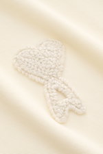 Close-up front view of the Ami Paris Polo shirt cream showing three-dimensional ‘A’ logo stitching on piqué cotton fabric.

<p>A casual classic among polo shirts: This piqué model in pure cotton with three-dimensional ‘A’ stitching on the chest comes in a