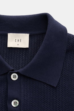 Nahaufnahme aus leicht schräger Perspektive des Ché Kurzarm-Strickpolo 'Quinn' navy/hellbraun mit luftigem Strickmuster, Polokragen und Zwei-Knopf-Leiste.