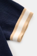 Nahaufnahme des Ärmels vom Ché Kurzarm-Strickpolo 'Quinn' navy/hellbraun mit luftigem Strickmuster und gestreiften Rippbündchen, fotografiert von oben.