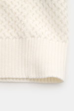 Nahaufnahme des Ché Kurzarm-Strickpolo 'Santino' creme, Detail des asymmetrischen Strickmusters, Rippbündchen aus reiner Baumwolle.