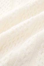 Nahaufnahme des groben, asymmetrischen Strickmusters des Ché Kurzarm-Strickpolo 'Santino' creme aus reiner Baumwolle.