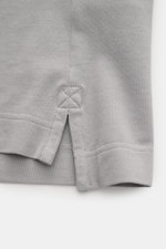 Nahaufnahme der seitlichen Saumschlitze des Canada Goose Poloshirt 'Beckley' grau aus Baumwoll-Piqué mit flexiblem Ärmelbündchen.