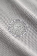 Canada Goose Poloshirt 'Beckley' grau aus Baumwoll-Piqué mit CANADA GOOSE-Patch, strukturiertem Griff, aus Nahaufnahme.