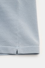 Close-up view of the hem and side slit of the C.P. Company Poloshirt rauchblau, made from soft, breathable pure cotton piqué with a slim fit and subtle textured finish. 

<p>Sportive Eleganz trifft auf Individualität: Das Poloshirt von C.P. COMPANY aus re