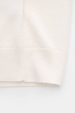 Close-up image from the side of the offwhite Iris von Arnim Kurzarm-Strickpolo "Pavion" showing the fine knit texture and ribbed hem. Luxuriöser Allrounder: Das edle Strickpolo von IRIS VON ARNIM verbindet Exklusivität mit unvergleichlichem Komfort und wi