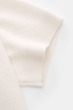 Close-up side view of the short sleeve and textured knit fabric of the Iris von Arnim Kurzarm-Strickpolo "Pavion" offwhite, showcasing its luxurious cashmere and silk blend, soft feel, regular fit, classic polo collar, and two-button placket. <p>Luxuriöse
