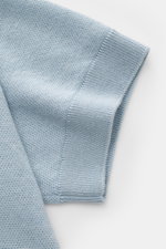 Nahaufnahme des hellblauen Iris von Arnim Kurzarm-Strickpolo 'Pavion' mit feinem Cashmere-Seide-Mix, weichem Griff und geripptem Ärmelbündchen, seitliche Perspektive.