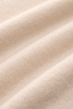 Close-up front view of the beige Iris von Arnim Kurzarm-Strickpolo 'Ameca' knit fabric, showcasing its soft texture and fine weave. Luxuriöser Allrounder: Das edle Strickpolo von IRIS VON ARNIM verbindet Exklusivität mit unvergleichlichem Komfort und wird