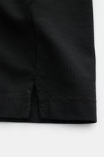 BRAUN Hamburg Jersey-Poloshirt schwarz, Detailaufnahme der seitlichen Saumschlitze aus reiner Baumwolle Jersey, Slim Fit, offene Kragenleiste, leicht griffige Haptik, fotografiert aus Nahaufnahme seitlich.