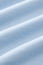 Nahaufnahme des hellblauen BRAUN Hamburg Jersey-Poloshirts, Jersey aus reiner Baumwolle, Slim Fit, offene Kragenleiste, seitliche Saumschlitze, leicht griffige Haptik.