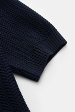 Nahaufnahme des Gran Sasso Kurzarm-Strickpolo navy von BRAUN HAMBURG, zeigt die markante Struktur und breite Rippbündchen am Ärmel, fotografiert von oben.
