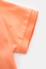 Polo Ralph Lauren Poloshirt orange, Nahaufnahme des kurzärmeligen Piqué-Jersey aus reiner Baumwolle, Slim Fit, mit elastischem Ärmelbündchen, typischem Polokragen und feiner Struktur, fotografiert aus seitlicher Perspektive.