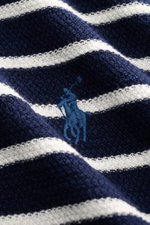 Nahaufnahme aus schräger Perspektive des Polo Ralph Lauren Kurzarm-Strickpolo navy/weiß gestreift mit maritimem Streifenmuster, labeltypischem Logo-Stitching, elastischen Bündchen und hochwertigem Baumwoll-Leinen-Mix für hohen Tragekomfort.