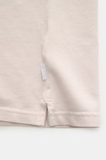 Nahaufnahme des unteren Saums vom 04651/ A trip in a bag Poloshirt 'Johnny' sand, Piqué Baumwolle, offener Kragen, Weblabel.