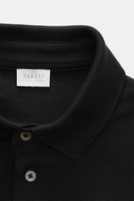 Close-up front view of 04651/ A trip in a bag Poloshirt 'TP' schwarz showing classic collar, smooth button placket, and soft cotton piqué fabric. <p>Ob im Urlaub oder Office: 04651/ A TRIP IN A BAG bringt mit dem Poloshirt aus reiner Baumwolle lässiges So